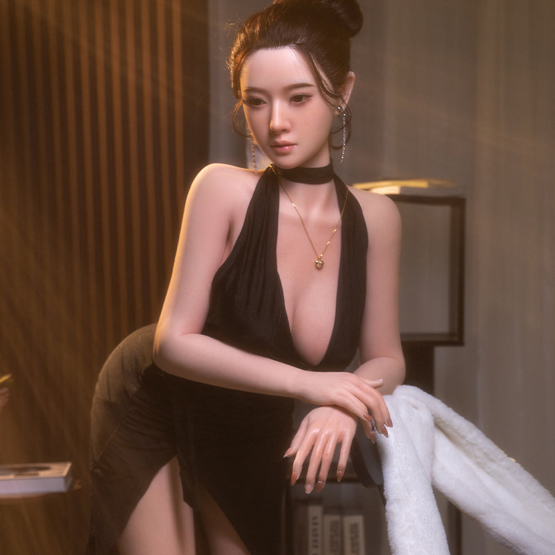 Lanxin, wearing a black halter-neck slit dress, is a mature, all-over silicone sex doll.
