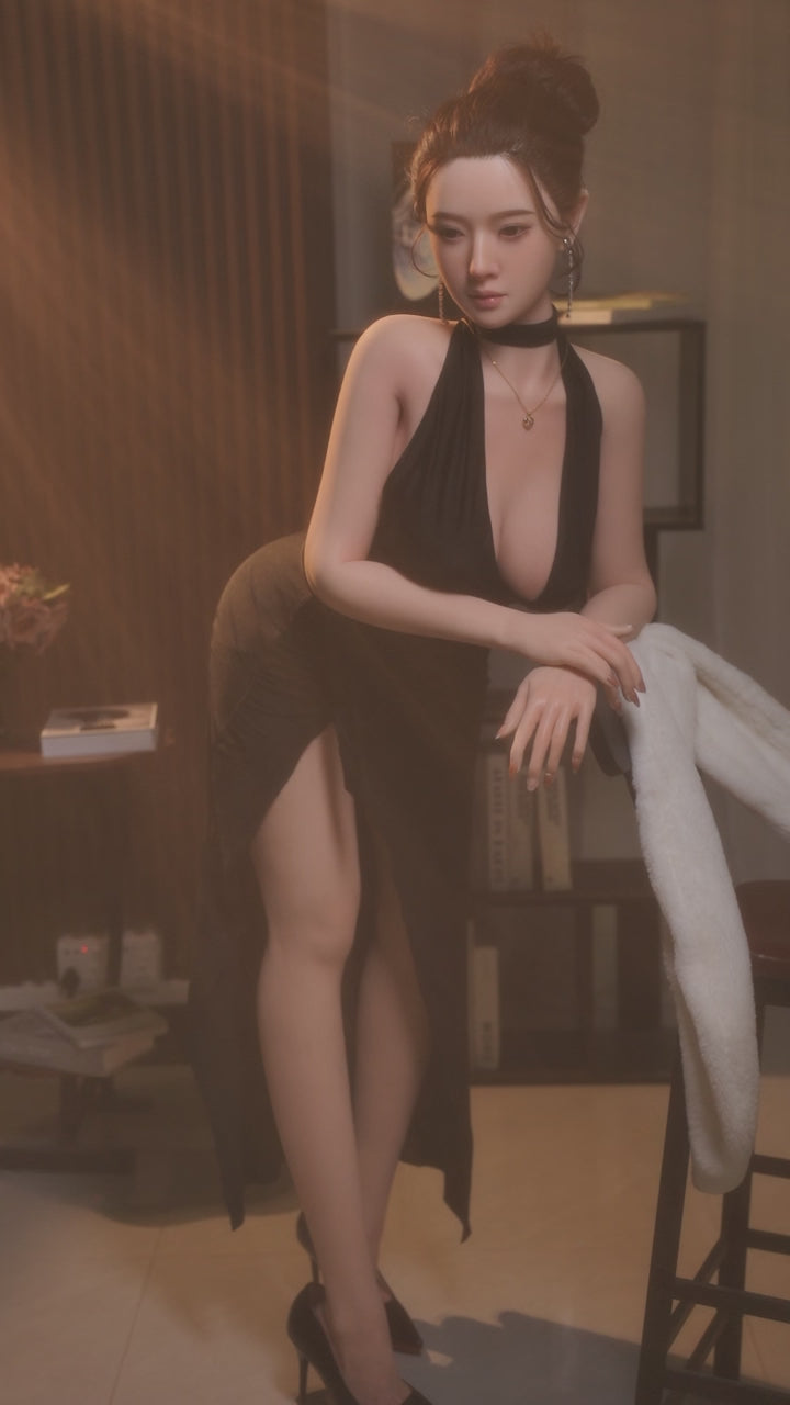 Lanxin, wearing a black halter-neck slit dress, is a mature, all-over silicone sex doll.