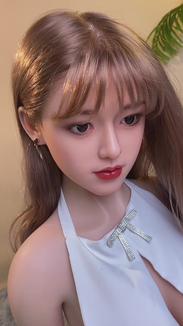 Haiyue, an Asian woman with long hair, full breasts, and a full-body silicone sex doll.
